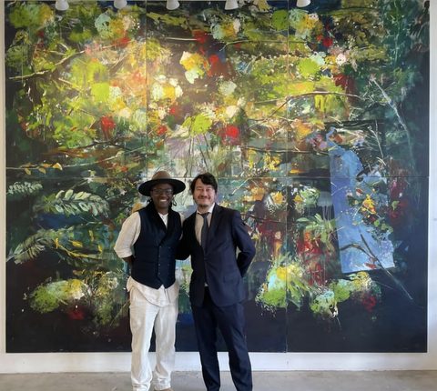 Yared Nigussu with the newly appointed French Consul General in the studio, before a large green botanical painting